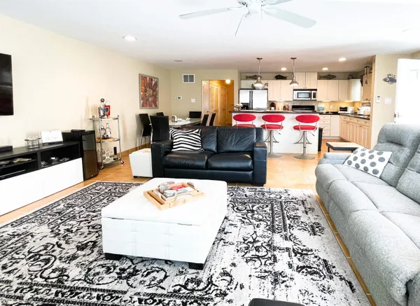 a living room with a couch and dining table with wooden floor