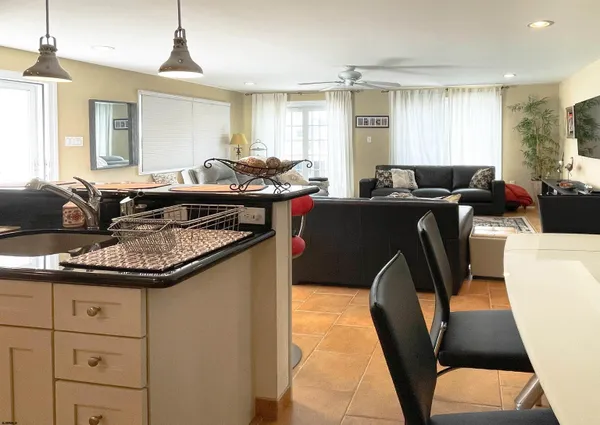 a living room with furniture a large window and wooden floors