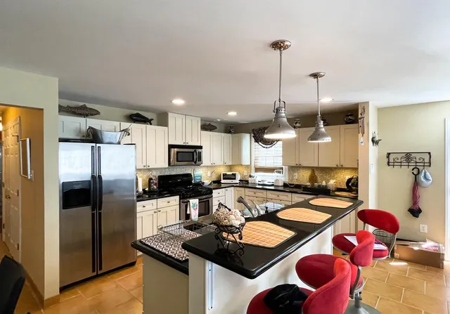 a kitchen with a refrigerator a stove top oven a sink and a center island