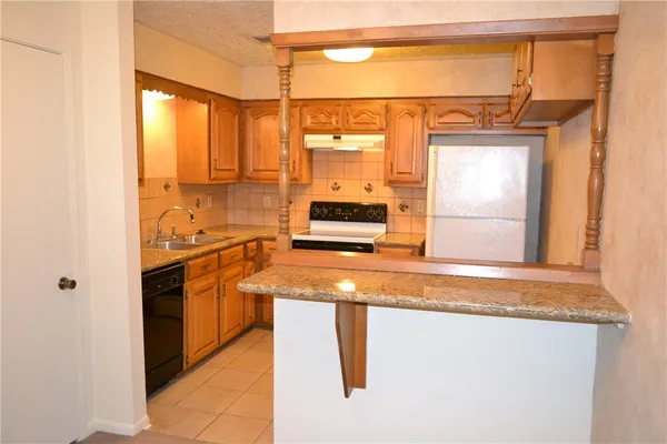 a kitchen with stainless steel appliances granite countertop a sink and a refrigerator