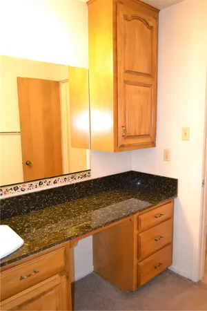 a view of kitchen with granite countertop cabinets and sink