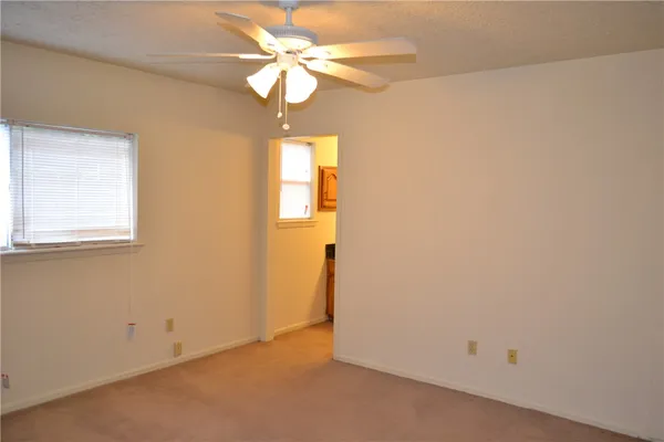 an empty room with a window and a ceiling fan