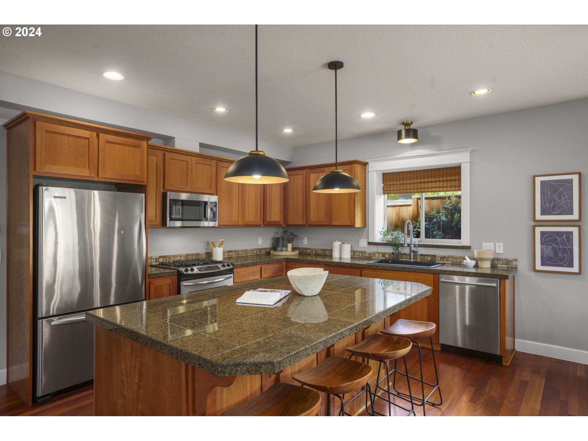 323 Southwest Carson Street Portland, OR 97219 - Photo 8 of 30 a kitchen with stainless steel appliances granite countertop a sink a stove a refrigerator cabinets and chairs