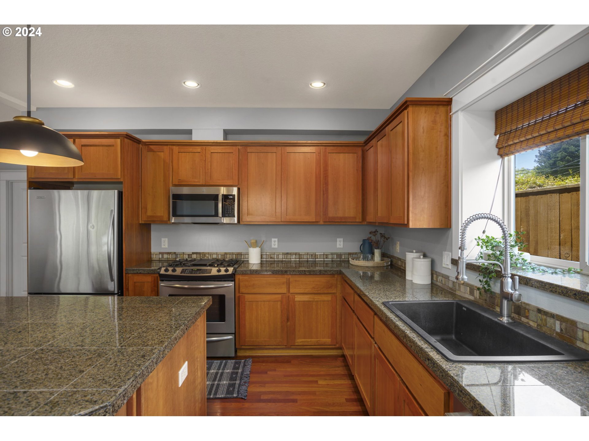 323 Southwest Carson Street Portland, OR 97219 - Photo 10 of 30 a kitchen with stainless steel appliances granite countertop a sink stove refrigerator and cabinets