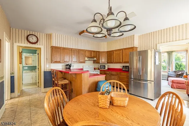 a kitchen with stainless steel appliances granite countertop a table and chairs in it
