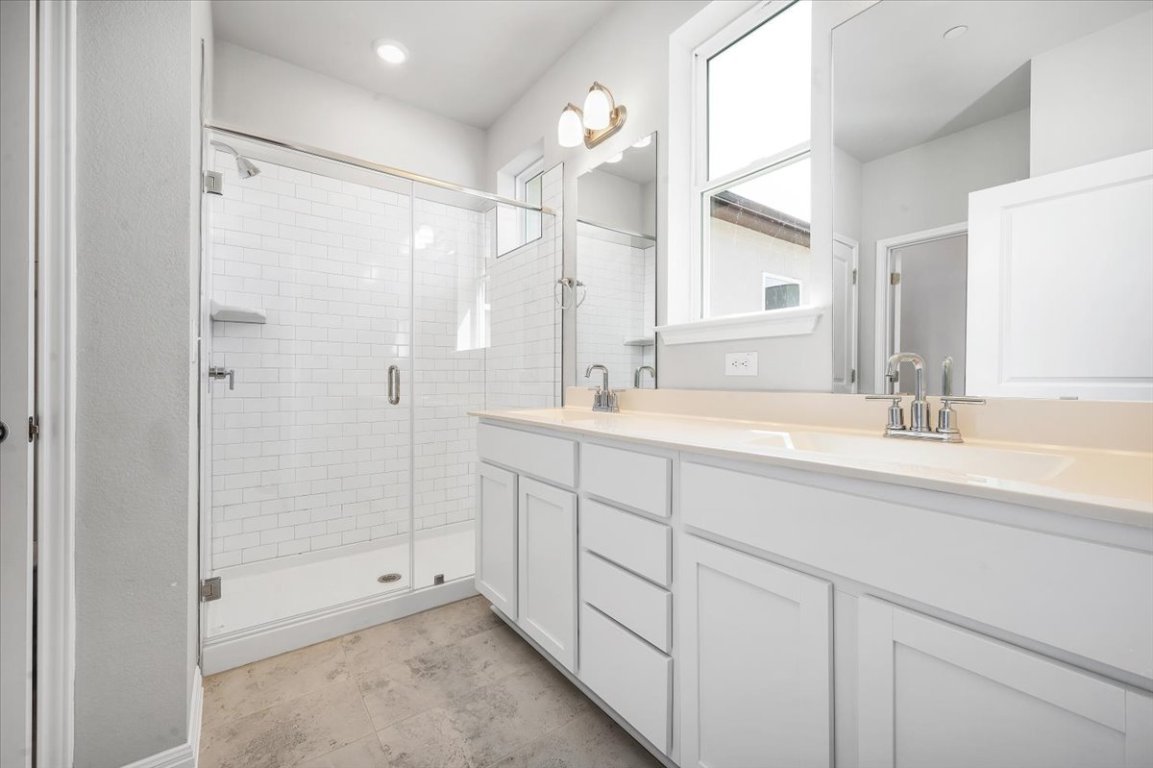 9015 Cattle Baron Path, Unit 1303 Austin, TX 78747 - Photo 14 of 14 a bathroom with a shower sink and mirror