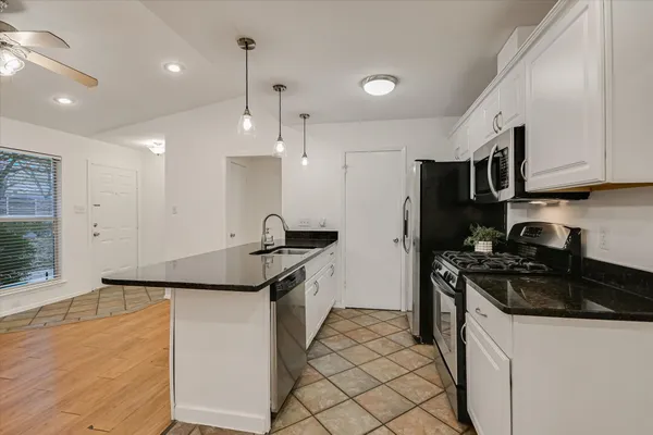 a kitchen with stainless steel appliances granite countertop a sink stove and refrigerator