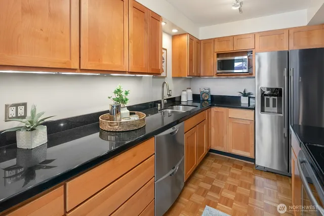 a kitchen with sink a microwave and cabinets