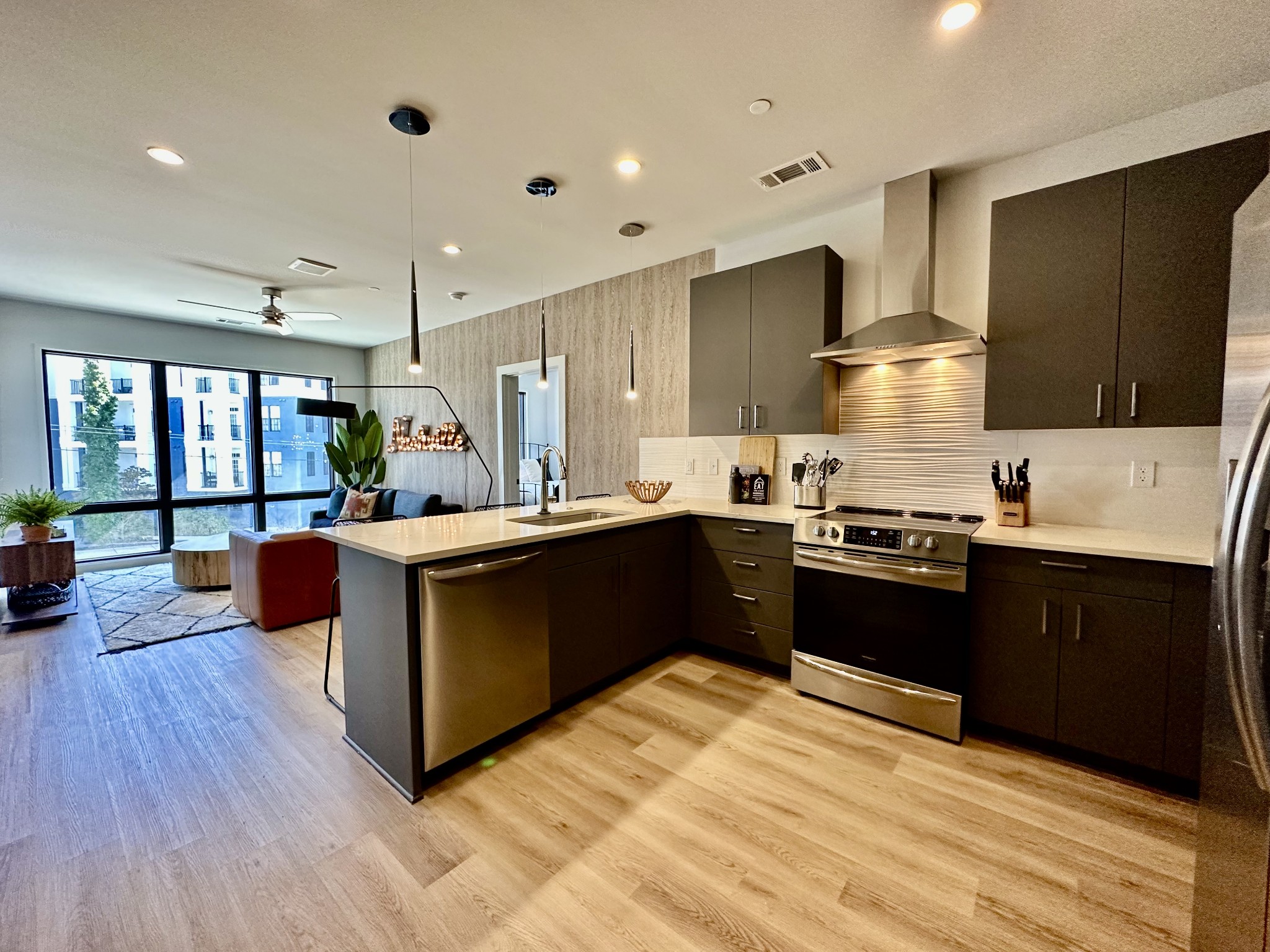 a kitchen with stainless steel appliances kitchen island granite countertop a stove a refrigerator a sink and a oven