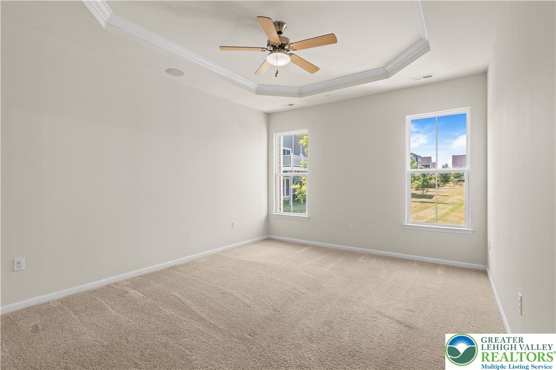 4758 Rafi Road Easton, PA 18045 - Photo 15 of 55 A tray ceiling with a modern ceiling fan complements the soft carpeting and ample natural light in this inviting space.