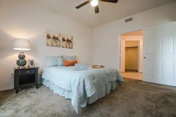 a bedroom with a bed and ceiling fan