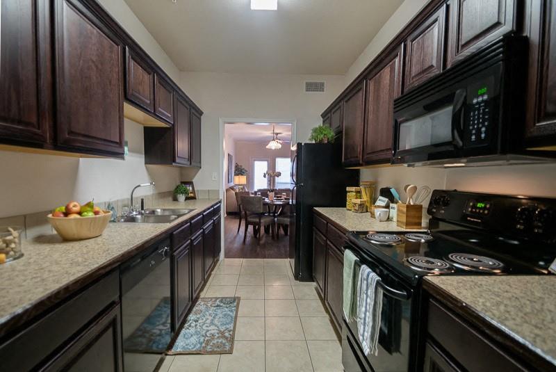 380 Solon Road Waxahachie, TX 75165 - Photo 6 of 12 a kitchen with granite countertop lots of stainless steel appliances granite countertop a sink a stove and a wooden cabinets