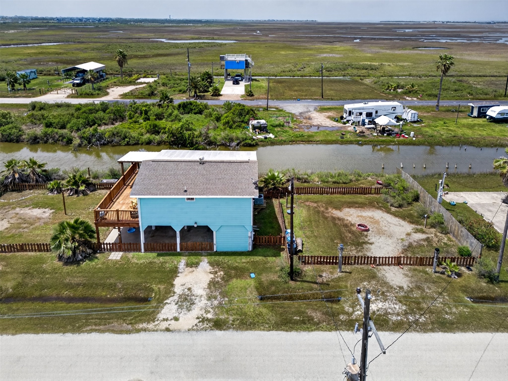 1209 North Jacks Road Crystal Beach, TX 77650 - Photo 30 of 39 Side view capturing the full lot, fenced yard, and proximity to the canal, offering space to spread out and enjoy coastal living.