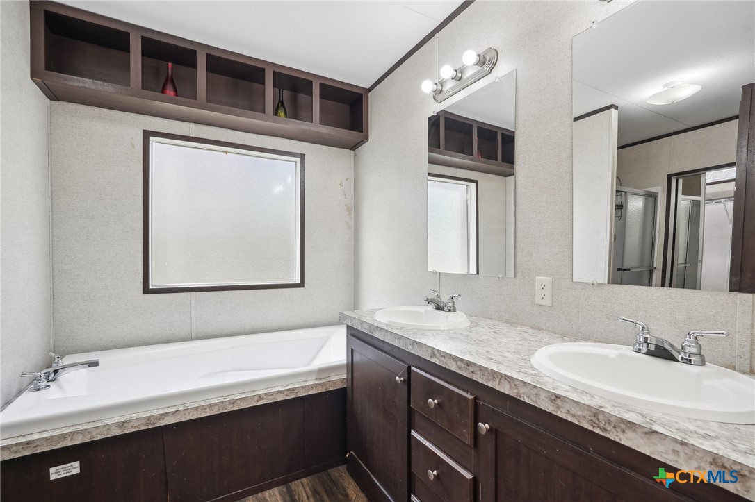 151 Deer River Drive Spring Branch, TX 78070 - Photo 17 of 29 a bathroom with a granite countertop sink mirror and bathtub