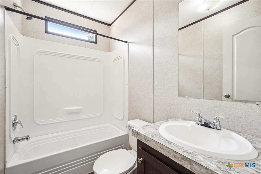 151 Deer River Drive Spring Branch, TX 78070 - Photo 24 of 29 a bathroom with a granite countertop sink toilet and shower
