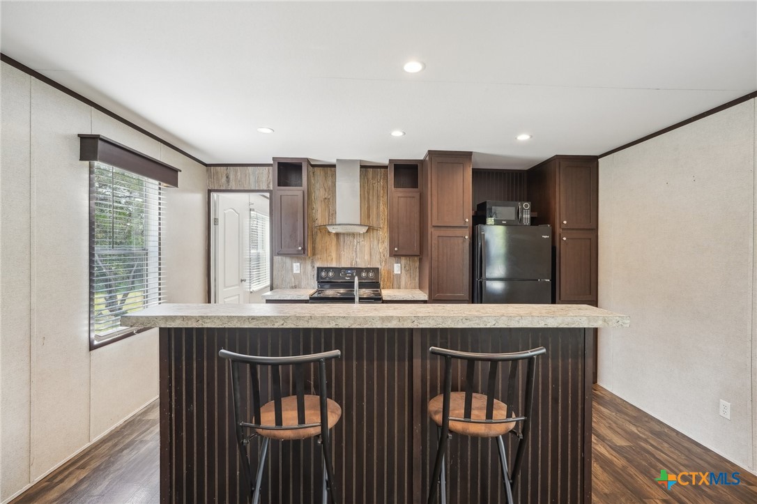 151 Deer River Drive Spring Branch, TX 78070 - Photo 9 of 29 a kitchen with stainless steel appliances granite countertop a stove a sink and a microwave