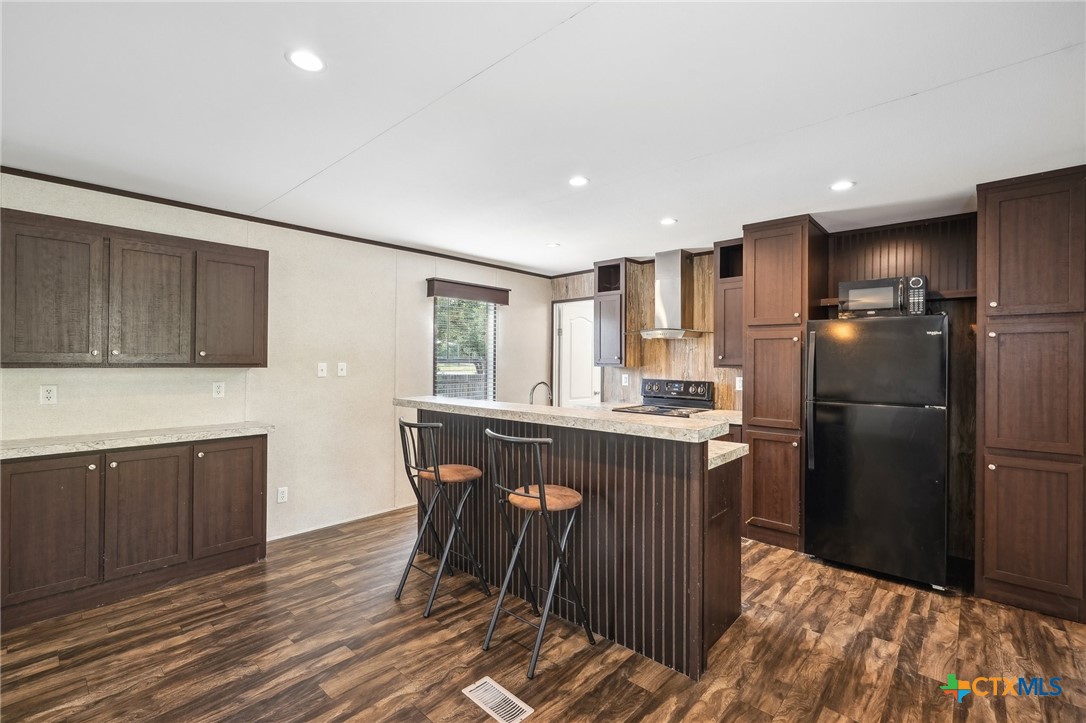 151 Deer River Drive Spring Branch, TX 78070 - Photo 10 of 29 a kitchen with kitchen island wooden cabinets a refrigerator stove a sink and dishwasher