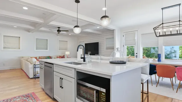 a view of kitchen island a sink and a stove