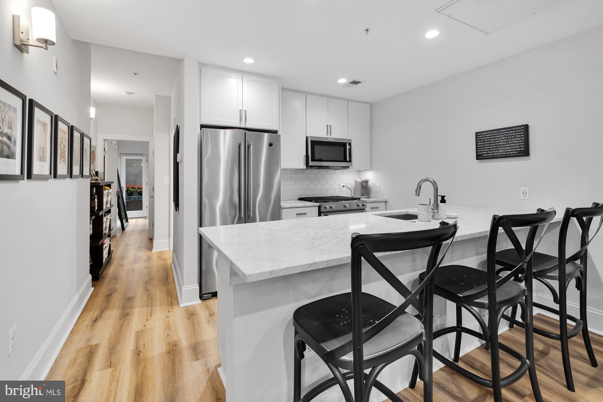 819 D Street Northeast, Unit 8 Washington, DC 20002 - Photo 11 of 26 a kitchen with stainless steel appliances kitchen island a refrigerator and a stove top oven