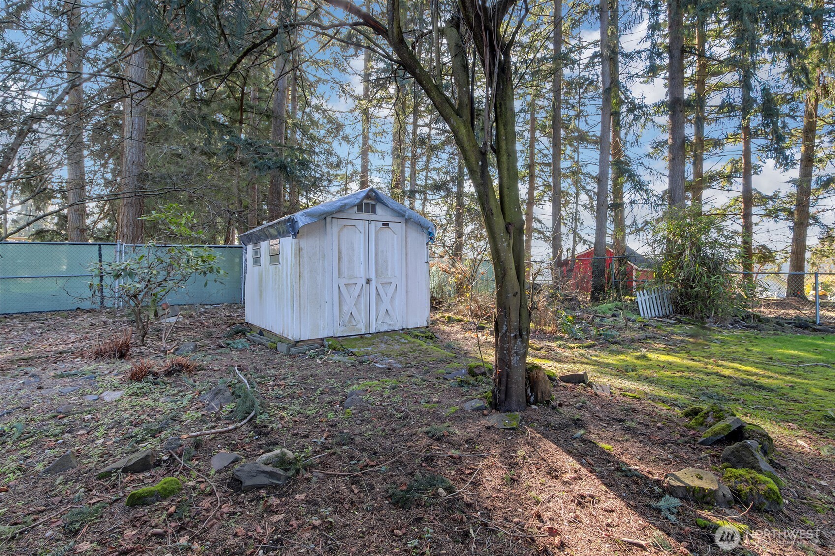 9314 Canyon Road East, Unit 34 Puyallup, WA 98371 - Photo 7 of 18 a view of a backyard with large trees and wooden fence