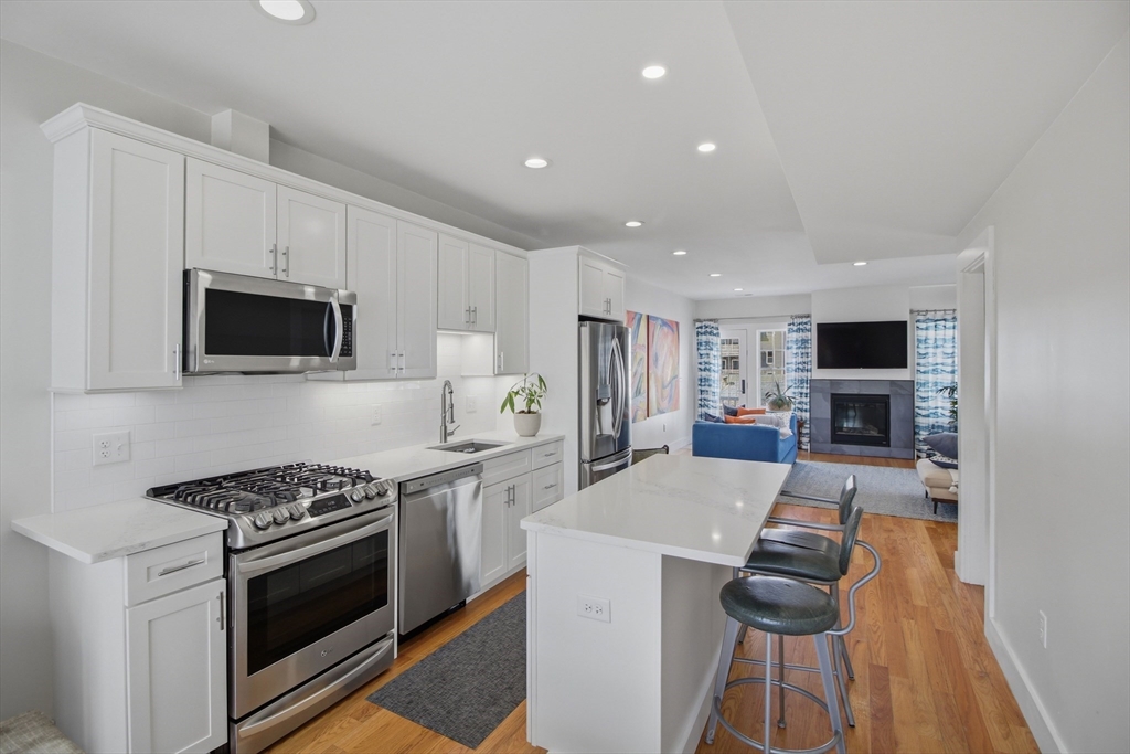 10 Berkley Road, Unit A Hull, MA 02045 - Photo 4 of 25 a kitchen with stainless steel appliances a stove a microwave a sink and a refrigerator