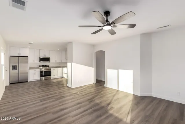 a view of a kitchen with a sink and dishwasher a refrigerator with wooden floor