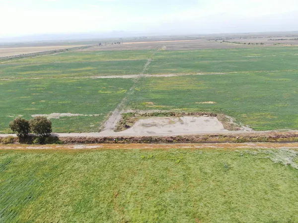 a view of a lake in middle of a field