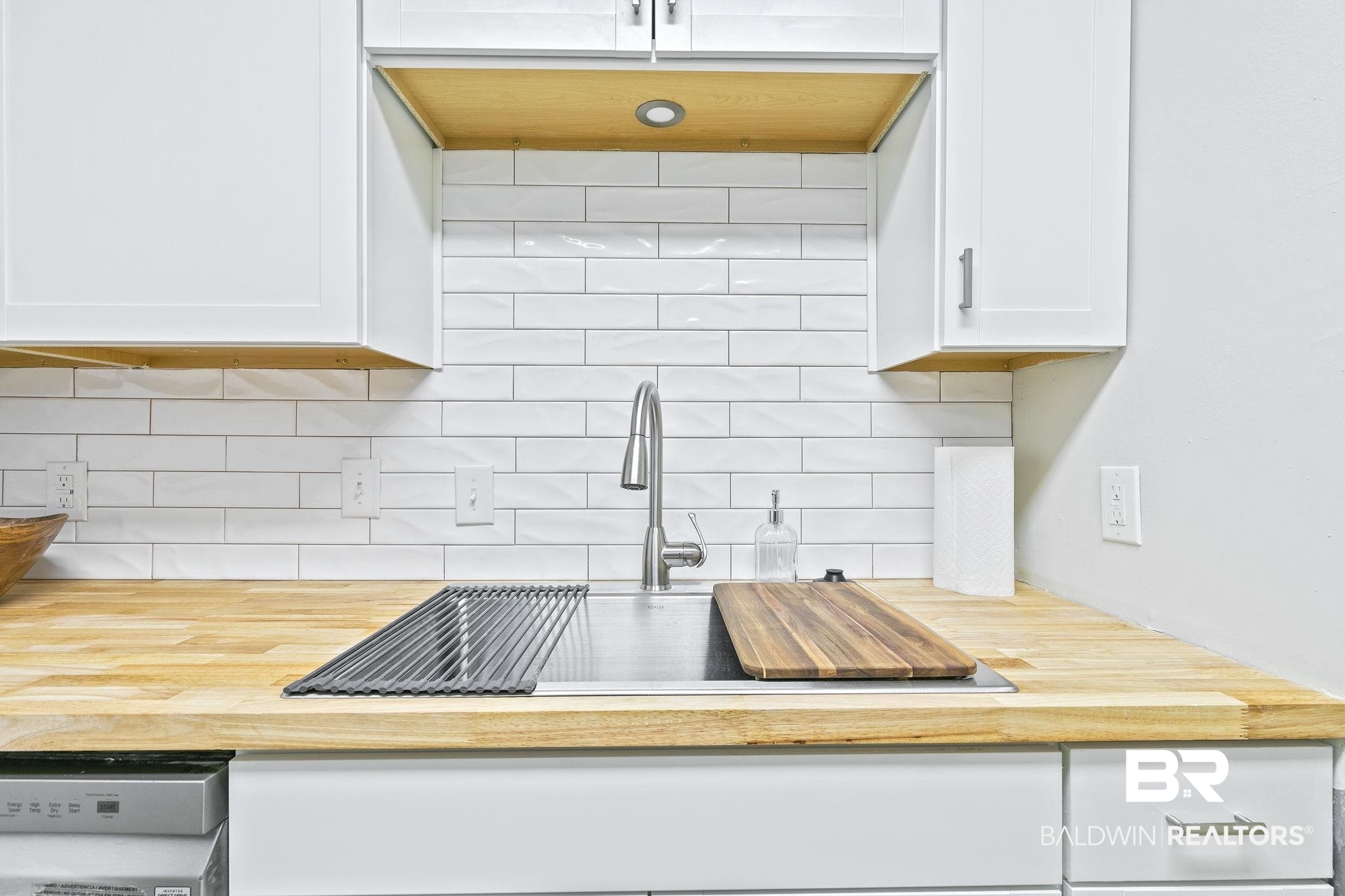 110 5th Street, Unit C103 Daphne, AL 36526 - Photo 21 of 46 Kitchen with white cabinetry, stainless steel dishwasher, and backsplash