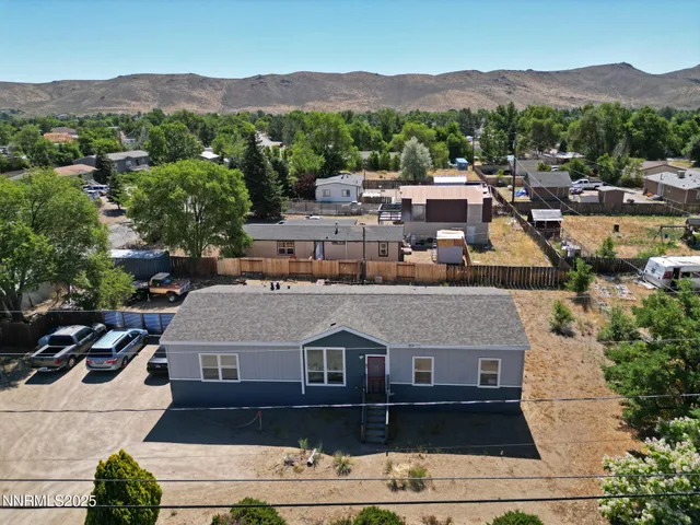 an aerial view of a house with a mountain in the background