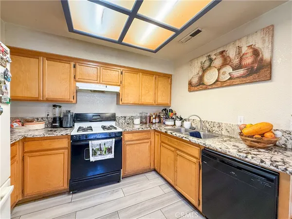 a kitchen with stainless steel appliances granite countertop sink stove and refrigerator