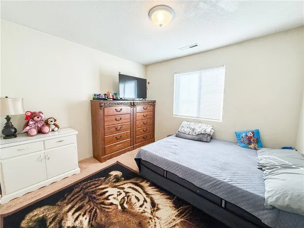 a bedroom with a bed and dresser with mirror