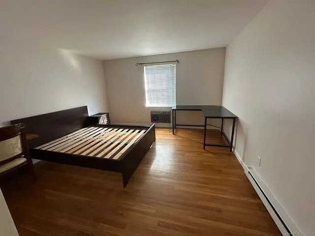 a bedroom with wooden floors and a bed