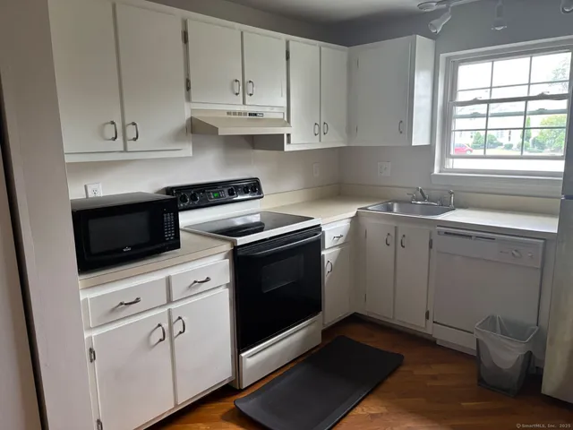 a kitchen with cabinets appliances and a window