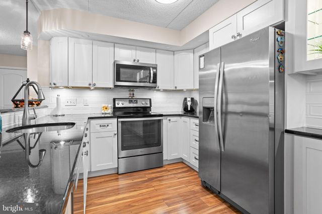 a kitchen with a table chairs and white cabinets