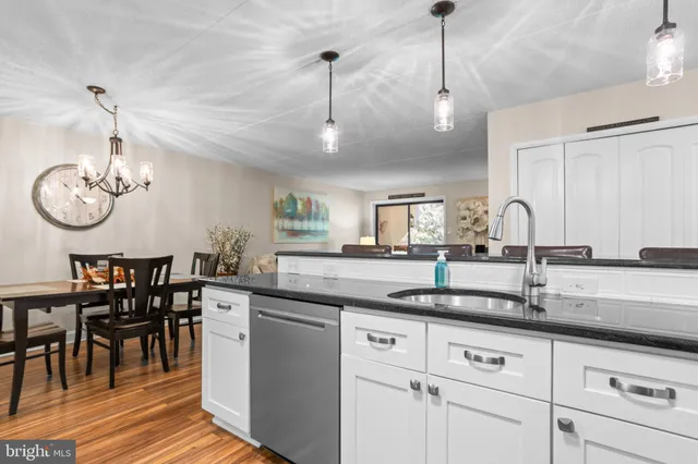 a view of a dining room with furniture a chandelier and wooden floor