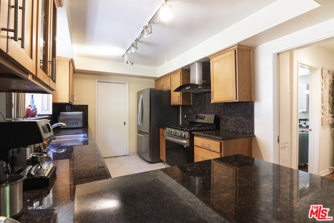 9527 Oakmore Road Los Angeles, CA 90035 - Photo 13 of 29 a kitchen with stainless steel appliances granite countertop a refrigerator and a stove top oven