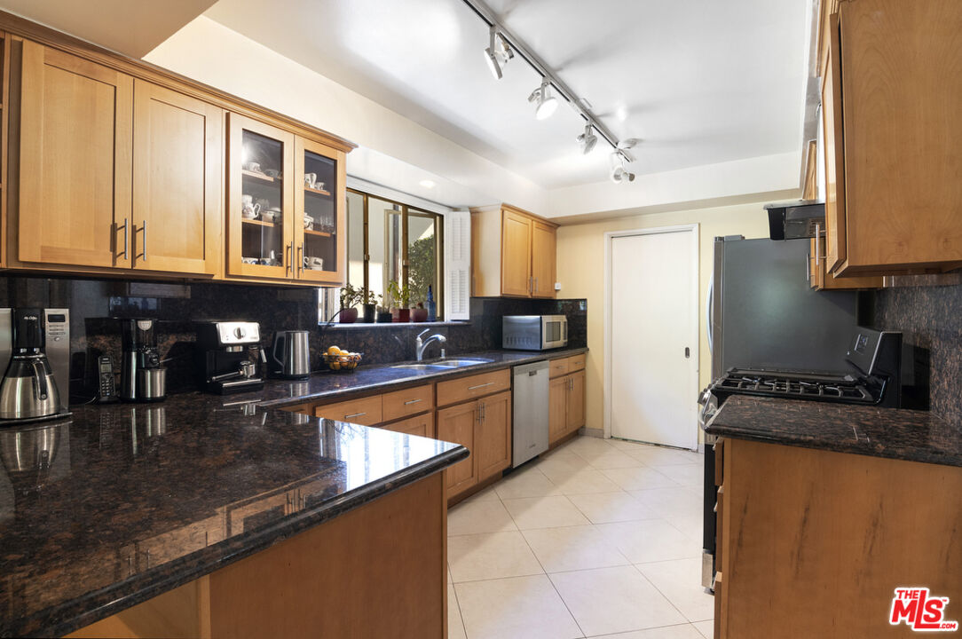 9527 Oakmore Road Los Angeles, CA 90035 - Photo 14 of 29 a kitchen with stainless steel appliances granite countertop a sink and cabinets