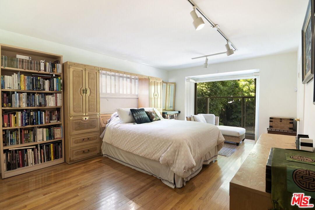 9527 Oakmore Road Los Angeles, CA 90035 - Photo 15 of 29 a bedroom with a bed a large window and book shelf