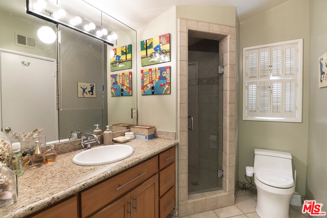 9527 Oakmore Road Los Angeles, CA 90035 - Photo 22 of 29 a bathroom with a granite countertop sink a toilet a shower and a mirror