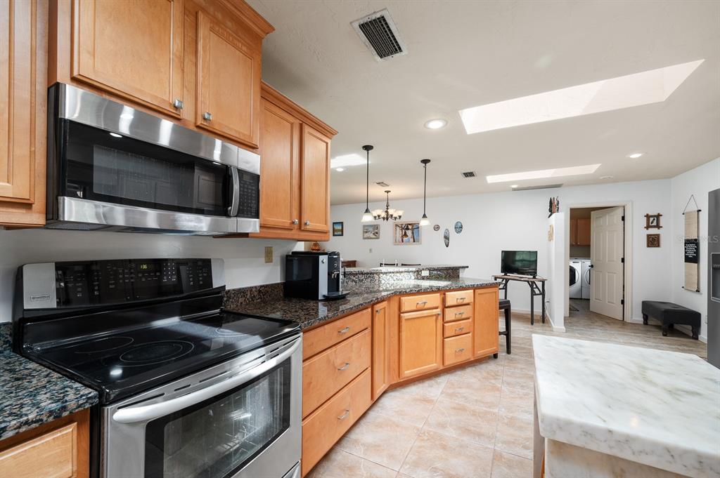 7201 Southwest 97th Lane Gainesville, FL 32608 - Photo 18 of 68 a large kitchen with stainless steel appliances granite countertop a stove and a sink