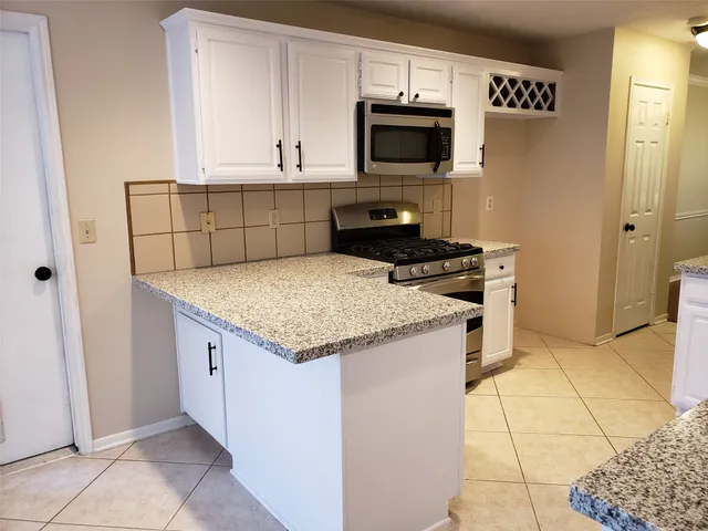 a kitchen with granite countertop a sink and a stove top oven
