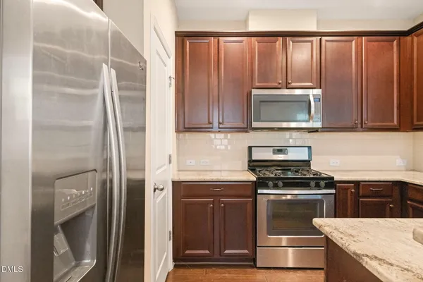 a kitchen with granite countertop cabinets stainless steel appliances and a sink