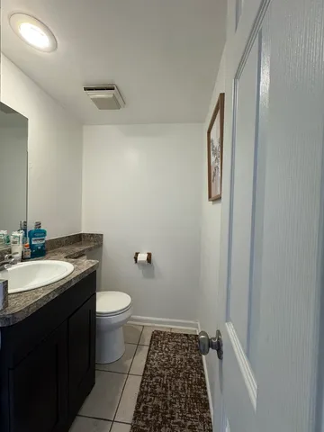 a bathroom with a granite countertop sink toilet and a mirror