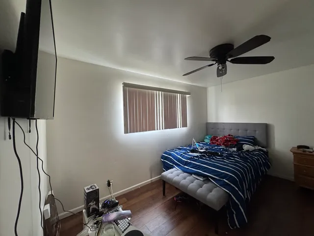 a bedroom with a bed and wooden floor