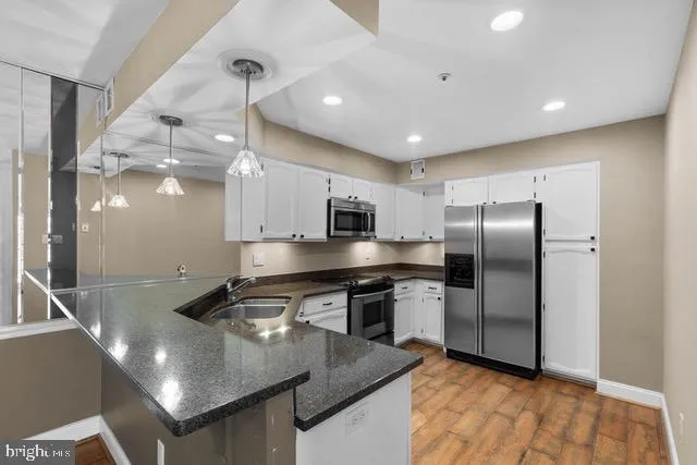 a kitchen with stainless steel appliances granite countertop a sink a stove and a refrigerator