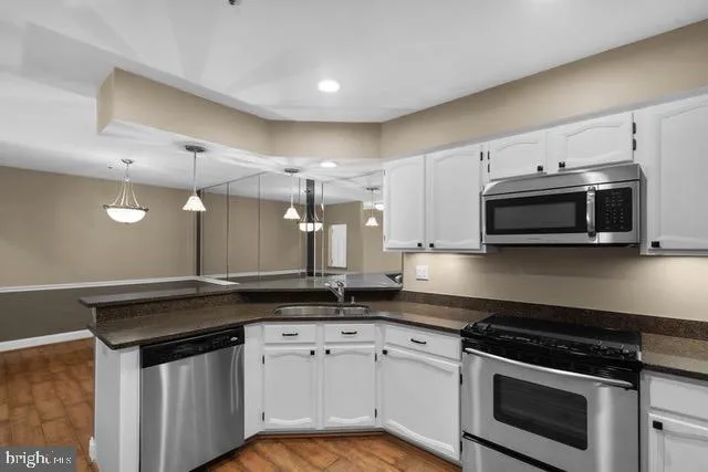 a kitchen with stainless steel appliances a stove a microwave and cabinets