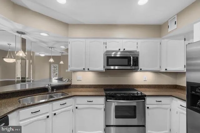 a kitchen with stainless steel appliances granite countertop a sink stove and cabinets