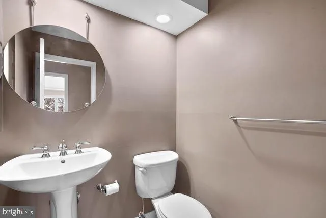 a bathroom with a toilet sink and mirror