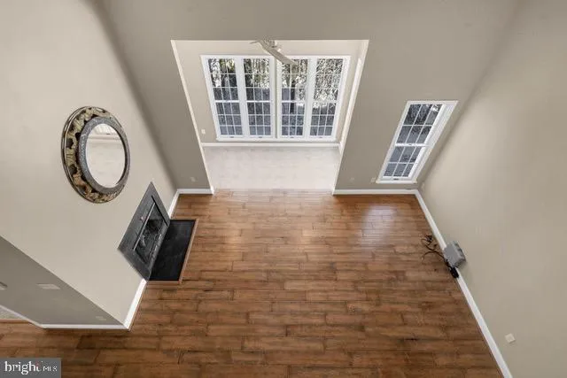 a view of a hallway with wooden floor and a window