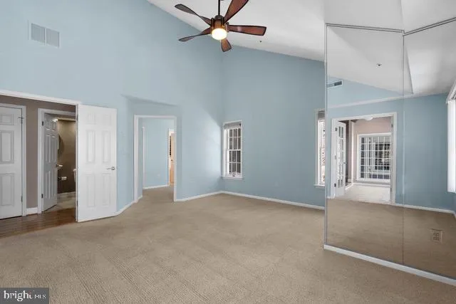 an empty room with windows and fan